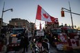 A demonstrator holds a Canadian flag during a protest by truck drivers over pandemic health rules and the Trudeau government in Ottawa on Tuesday, Feb. 15, 2022.