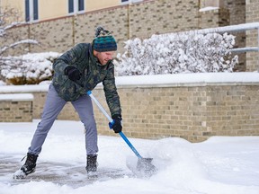 Seth Bussey, associate youth pastor at Calgary Central Seventh-day Adventist Church, shovels the snow on the sidewalk on Wednesday, February 16, 2022.