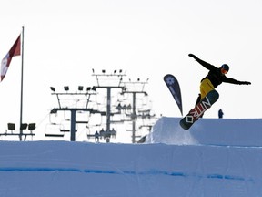 A snowboarder makes a jump off a ramp at WinSport.