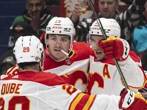 Flames forward Matthew Tkachuk celebrates a first-period goal with teammates Dillon Dube and Mikael Backlund in Saturday night's late date with the Canucks at Rogers Arena in Vancouver.
