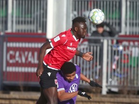 Cavalry FC’s Karifa Yao goes high over a Pacific FC defender during a CPL semifinal at ATCO Field at Spruce Meadows on Nov. 20, 2021.