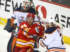 Calgary Flames forward Elias Lindholm battles with Edmonton Oilers defenceman Duncan Kieth at Scotiabank Saddledome on Saturday, March 26, 2022.