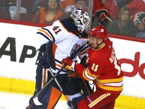 Edmonton Oilers goaltender Mike Smith and Calgary Flames forward Mikael Backstrom collide at Scotiabank Saddledome on Saturday, March 26, 2022.