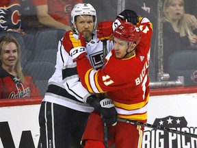Calgary Flames centre Mikael Backlund battles Los Angeles Kings defenceman Alexander Edler in first period NHL action at the Scotiabank Saddledome in Calgary on Thursday, March 31, 2022.