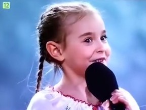 Wearing a white folk dress embroidered with red, white and blue flowers, Amelia took center stage and sang Ukraine's anthem, "Ukraine has not yet perished," to an audience in Poland.