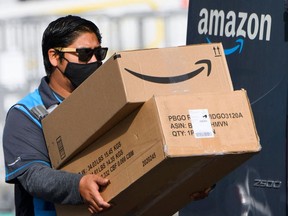 An Amazon delivery driver carries boxes into a van outside of a distribution facility in Hawthorne, California. Amazon.com Inc. is pausing plans for its annual sale Prime Day in Canada and India due to concerns about COVID-19. The pause won't affect Prime Day in the U.S.