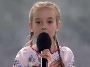 Amellia Anisovych, little girl holding big microphone to her mouth, singing.