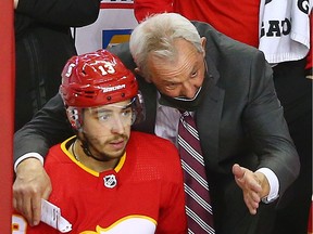 Calgary Flames head coach Darryl Sutter talks with forward Johnny Gaudreau during a game against the Montreal Canadiens at the Scotiabank Saddledome in Calgary on March 13, 2021.
