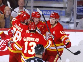 L'attaquant des Flames de Calgary Tyler Toffoli (centre, arrière) célèbre avec ses coéquipiers après avoir marqué contre le gardien de but des Oilers d'Edmonton Mikko Koskinen au Scotiabank Saddledome de Calgary le lundi 7 mars 2022.