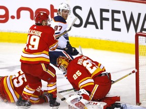 Calgary Flames goaltender Jacob Markstrom stops Edmonton Oilers forward Connor McDavid as Matthew Tkachuk and Noah Hanifin defend at Scotiabank Saddledome in Calgary on March 7, 2022.