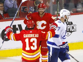 Calgary Flames forward Johnny Gaudreau celebrates his hat-trick goal against the Tampa Bay Lightning with Elias Lindholm at Scotiabank Saddledome in Calgary on Thursday, March 10, 2022.