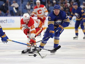 Calgary Flames centre Blake Coleman battles Buffalo Sabres winger John Hayden at KeyBank Center in Buffalo, N.Y., on Nov. 18, 2021.