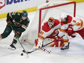 Minnesota Wild winger Kevin Fiala has the puck tipped off his stick by Calgary Flames defenceman Chris Tanev with goaltender Jacob Markstrom at the ready during the second period of Tuesday night's NHL game in St. Paul, Minn.