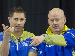 John Morris and Kevin Koe strategize during the Brier in Lethbridge.