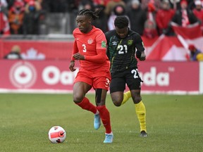 Canada defender Sam Adekugbe dribbles the ball away from Jamaica forward Javain Brown during a FIFA World Cup qualifying match at BMO Field in Toronto on Sunday, March 27, 2022.