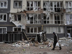 A man walks past a heavily damaged apartment building on April 4, 2022 in Bucha, Ukraine.