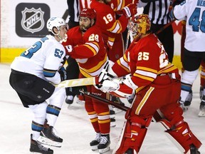 Calgary Flames goalie Jacob Markstrom battles San Jose Sharks defenceman Nicolas Meloche at the Scotiabank Saddledome in Calgary on March 22, 2022.