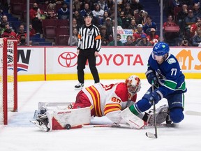 Calgary Flames goalie Dan Vladar stops Vancouver Canucks defencenman Brad Hunt at Rogers Arena in Vancouver on March 19, 2022.