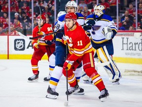 Calgary Flames center Mikael Backlund and St. Louis Blues center Robert Thomas face off at the Scotiabank Saddledome in Calgary on Saturday, April 2, 2022.