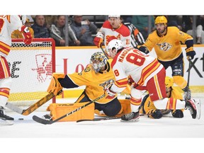 Flames winger Andrew Mangiapane scores one of his two goals on Nashville Predators goaltender Juuse Saros last night at Bridgestone Arena.