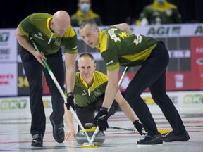 Northern Ontario skip Brad Jacobs follows his front end  of lead Ryan Harnden (left) and second E.J. Harnden during the Tim Hortons Brier in Lethbridge, Alta., on March 8, 2022.