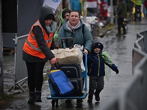 Refugees and volunteers are seen at the Medyka border crossing as people pass into Poland from war-torn Ukraine on March 31, 2022.