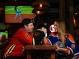 Flames fan Mike Lower, Pig and Duke chef, and Oilers fan Lisa Kulyk, Royal Exchange general manager, pose for a photo at Pig and Duke on Monday, May 16, 2022.