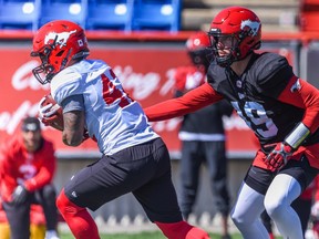 Bo Levi Mitchell hands the ball to Ryan Gomes during Calgary Stampeders training camp at McMahon Stadium on Monday, May 23, 2022.