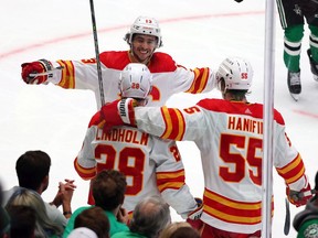 The Calgary Flames’ Johnny Gaudreau, Elias Lindholm and Noah Hanifin celebrate a goal against the Dallas Stars during Game 4 of their first-round series at American Airlines Center in Dallas on Monday, May 9, 2022.