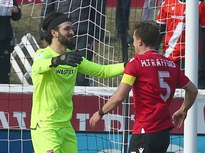 Cavalry FC’s Marco Carducci and Mason Trafford hug at the final whistle and a 2-0 win against Pacific FC on ATCO Field at Spruce Meadows on Sunday, May 1, 2022.