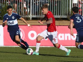 Cavalry FC’s Myer Bevan charges upfield between Vancouver Whitecaps defenders Cristian Gutierrez (left) and Russell Teibert during their Canadian Championship quarterfinal on ATCO Field at Spruce Meadows on Wednesday, May 25, 2022.
