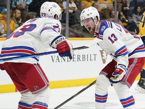 New York Rangers left wing Alexis Lafreniere (13) celebrates with Adam Fox (23) after Lafreniere scored a goal against the Nashville Predators in the third period of an NHL hockey game Thursday, Oct. 21, 2021, in Nashville, Tenn. The Rangers won 3-1.