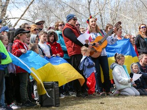 Guests at a BBQ picnic for Ukrainians fleeing war take part in a flash mob singing of the Ukrainian military anthem at Bowness Park in Calgary on Sunday, May 1, 2022.