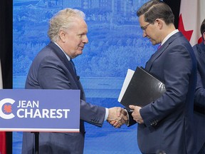 Conservative leadership candidates Jean Charest and Pierre Poilievre shake hands at the conclusion of the Conservative Party of Canada English leadership debate on Wednesday, May 11, 2022 in Edmonton.