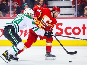 Calgary Flames center Dillon Dube (29) and Dallas Stars defenseman Joel Hanley (44) battle for the puck during the third period in Game 5 of the first round of the 2022 Stanley Cup Playoffs at Scotiabank Saddledome on May 11, 2022.