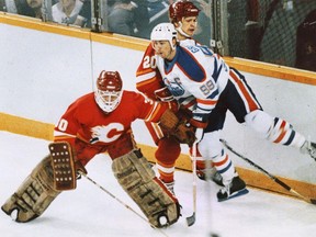 Edmonton Oilers forward Wayne Gretzky gets hit by Calgary Flames defenceman Gary Suter and goalie Mike Vernon during their 1986 playoff series.