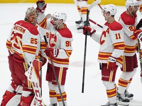 Calgary Flames goaltender Jacob Markstrom (25) celebrates with Calle Jarnkrok (91) following Game 4 of an NHL hockey Stanley Cup first-round playoff series against the Dallas Stars, Monday, May 9, 2022, in Dallas. Mikael Backlund (11) is at right.