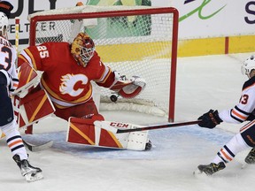 Jacob Markstrom of the Calgary Flames keeps this puck out of the net with centre Ryan Nugent-Hopkins of the Edmonton Oilers attacking during the first period of action as the Calgary Flames host the Edmonton Oilers in Game 2 of the second round of the Stanley Cup Playoffs at the Saddledome. Friday, May 20, 2022. Brendan Miller/Postmedia
