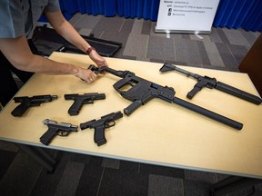 Seized firearms are displayed during an RCMP and Crime Stoppers news conference at RCMP headquarters in Surrey, B.C., May 17, 2021.