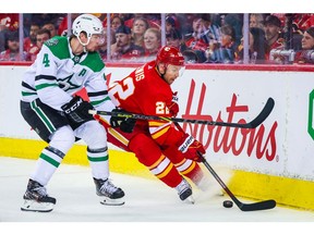 Calgary Flames center Trevor Lewis (22) and Dallas Stars defenseman Miro Heiskanen (4) battle for the puck during the third period in game two of the first round of the 2022 Stanley Cup Playoffs at Scotiabank Saddledome.