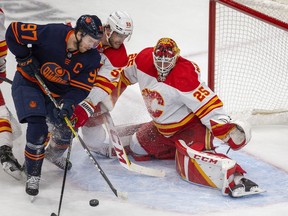 Edmonton Oilers forward Connor McDavid battles with Calgary Flames defenceman Noah Hanifin in front of goaltender Jacob Markstrom during Game 3 of their first-round series at Rogers Place in Edmonton on Sunday, May 22, 2022.