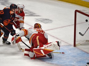 Edmonton Oilers forward Ryan Nugent-Hopkins scores the eventual game-winner on Calgary Flames goalie Jacob Markstrom while battling defenceman Oliver Kylington during Game 4 of their second-round playoff series 
at Rogers Place in Edmonton on May 24, 2022.