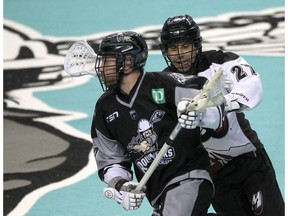 Roughneck Zach Currier dives the ball while defended by Mammoth Scott Carnegie during the first half of action as the Calgary Roughnecks host the Colorado Mammoth at the Saddledome. Friday, February 11, 2022. Brendan Miller/Postmedia