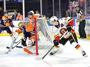 Stockton Heat forward Matthew Phillips skates around the net as Bakersfield Condors goaltender Stuart Skinner defends.