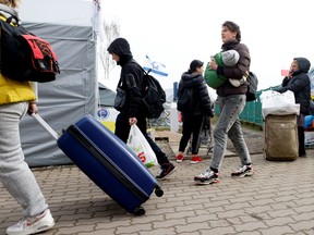 Ukrainian refugees walk after crossing the Ukraine-Poland border, amid the Russian invasion of Ukraine, in Medyka, Poland, April 10, 2022.