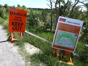 Signs warning residents and pathway users of possible dangers at the top of McHugh Bluff on Crescent Rd NW in Calgary on Wednesday, June 22, 2022.