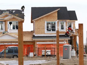 Construction workers work on new homes in the Livingstone community in northwest Calgary on Wednesday, January 30, 2019.