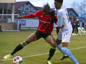 Cavalry FC Jean-Aniel Assi takes the ball to the corner in front of Edmonton's Courtney Jr Mitchell-Smith during Canadian Championship soccer action between Cavalry FC and FC Edmonton in Calgary at ATCO Field at Spruce Meadows in Calgary on Tuesday, May 10, 2022. Jim Wells/Postmedia