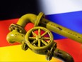 3D printed Natural Gas Pipes are placed on displayed German and Russian flags in this illustration taken, Jan. 31, 2022.