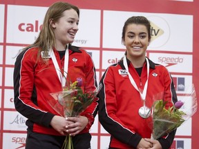 Margo Erlam, à gauche, et Ashley McCool du Canada célèbrent leur médaille d'argent lors de la finale ouverte féminine de trois mètres synchronisée lors du Grand Prix de plongeon FINA de la Coupe Canada à Calgary le 13 mai 2018.